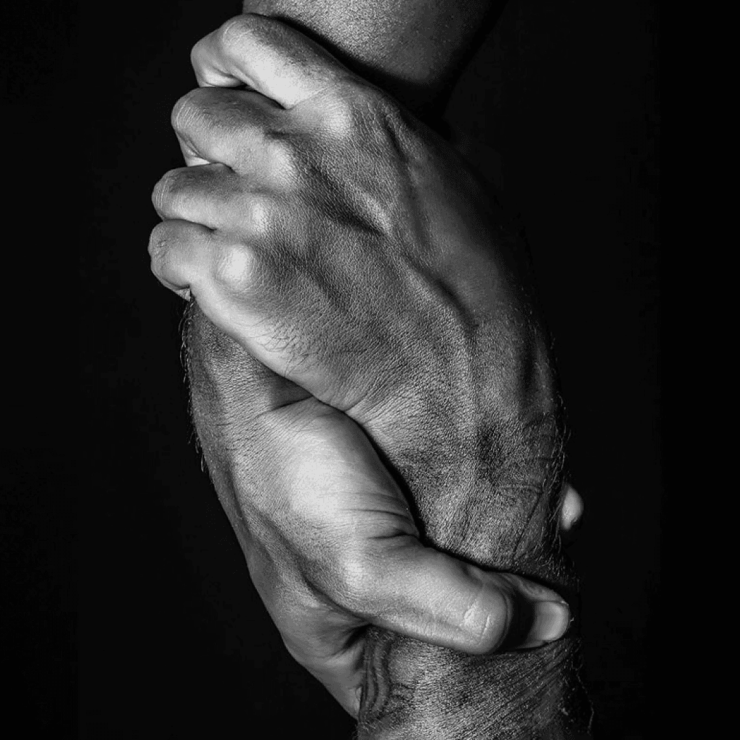 Two hands clasped together, symbolizing unity and support, representing Co-hesion's focus on cultural change and leadership.